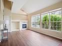 Sunlit living room features a fireplace, vaulted ceilings, and large windows showcasing outdoor views at 8371 S Upham Way # 103, Littleton, CO 80128