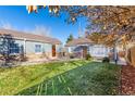 Home exterior featuring a well-maintained lawn, stone accents, and a charming pathway leading to the front door at 1050 S Raleigh St, Denver, CO 80219