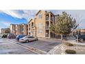 View of the apartments with stone accents, balconies, and ample parking space at 17525 Wilde Ave # 307, Parker, CO 80134