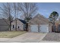 Charming brick home featuring a well-manicured front lawn, mature trees, and a two-car garage at 7006 S Miller Ct, Littleton, CO 80127