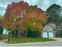 A lovely home featuring a large tree with vibrant fall foliage and pumpkins decorating the front lawn at 7006 S Miller Ct, Littleton, CO 80127