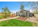 Quaint backyard featuring a stone walkway, lush lawn, and well-maintained landscaping at 1000 S Perry St, Denver, CO 80219