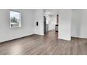 Open-concept living room showcasing new flooring and a glimpse into the modern kitchen with stainless steel appliances at 1000 S Perry St, Denver, CO 80219