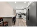 Modern kitchen with white cabinets, stainless steel appliances, and breakfast bar at 420 Racine St, Aurora, CO 80011