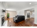 Living room with hardwood floors, fireplace, and view into kitchen at 420 Racine St, Aurora, CO 80011