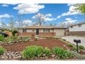 Charming single-story home with manicured front yard, complemented by blue skies at 1772 S Pierce St, Lakewood, CO 80232