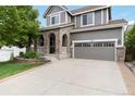 Charming two-story home featuring a brick facade, covered porch and manicured lawn, showcasing curb appeal at 2828 Shadow Dance Dr, Castle Rock, CO 80109