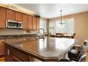 Spacious kitchen features a large island, wood cabinets, granite countertops, and stainless steel appliances at 2828 Shadow Dance Dr, Castle Rock, CO 80109