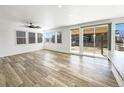 Sun-filled living room with luxury vinyl plank flooring, windows, and sliding doors at 4742 Quandary Peak St, Brighton, CO 80601