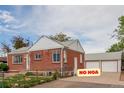 Cozy brick house with a detached garage and well-maintained landscaping at 8110 Ivy St, Commerce City, CO 80022