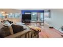 Comfortable living room with wood floors and an adjacent balcony offering city views at 100 W Park Ave Ave # 908, Denver, CO 80205