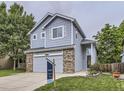 Charming two-story home featuring blue siding, brick accents, and a well-manicured front yard at 6447 St Vrain Ranch Blvd, Longmont, CO 80504