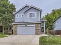 Charming two-story home featuring blue siding, brick accents, and a well-manicured front yard at 6447 St Vrain Ranch Blvd, Longmont, CO 80504