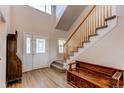 Inviting foyer with a staircase, bench, and hardwood floors at 895 Antelope W Dr, Bennett, CO 80102