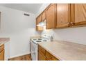Well-lit kitchen offering wood cabinets, a white range, and neutral countertops at 3613 S Sheridan Blvd # 7, Denver, CO 80235
