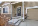 Inviting front porch with stone accents, a decorative wreath on the door, and a two-car garage to the side at 14799 Longhorn Dr, Mead, CO 80542