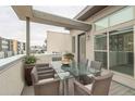 Spacious patio with glass-top table and wicker chairs, offering city views at 2692 Front View Cres, Denver, CO 80211