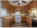 Traditional kitchen with wooden cabinets, light countertops, gas range, and wood-look flooring at 1099 Wheeling St, Aurora, CO 80011