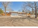 Traditional brick home featuring a two-car garage, white picket fence, and long driveway at 2372 Haskell Way, Watkins, CO 80137