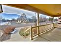 View from covered front porch with white railings looking out to neighborhood street at 288 Dover Ct, Broomfield, CO 80020