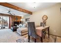 Cozy living room with fireplace, wood accent wall, ceiling fan, and dining area at 3355 Hickok Pl, Boulder, CO 80301