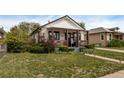 This single-story house has a welcoming front porch and an expansive green lawn at 3464 S Downing St, Englewood, CO 80113