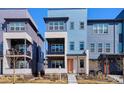 Stylish townhome with a balcony, modern design, and a striking orange front door at 6240 N Dayton Ct, Denver, CO 80238