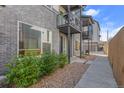 Street-level view of a townhouse with brick facade and metal porch covers and manicured landscaping at 5173 Vivian St, Wheat Ridge, CO 80033