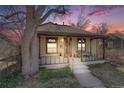 Inviting home showcasing a quaint covered porch, perfect for enjoying serene evenings and a colorful sky at 306 E Cannon St, Lafayette, CO 80026