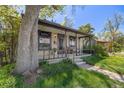 Charming home featuring a cozy front porch, lush lawn, and mature tree for shade at 306 E Cannon St, Lafayette, CO 80026