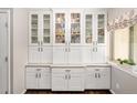 Stylish butler pantry features white cabinets, glass doors, and a sleek countertop perfect for entertaining and showcasing decor at 12662 W Asbury Pl, Lakewood, CO 80228