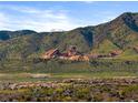 Scenic view featuring Red Rocks Amphitheater nestled amidst lush green hills, with houses in the foreground at 12662 W Asbury Pl, Lakewood, CO 80228