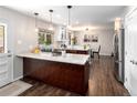 Bright kitchen with granite counters, wood floors, an island, and stainless steel appliances at 12662 W Asbury Pl, Lakewood, CO 80228