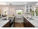 Modern kitchen with granite countertops, stainless steel appliances, and stylish lighting fixtures at 12662 W Asbury Pl, Lakewood, CO 80228