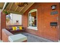 Cozy front porch with a porch swing, decorative pillows, hanging plants, and a view of the street at 2945 Grove St, Denver, CO 80211