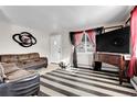 Living room with striped floors and a brown leather couch at 7111 Monaco St, Commerce City, CO 80022