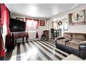 Living room features hardwood floors and a large flat-screen TV at 7111 Monaco St, Commerce City, CO 80022