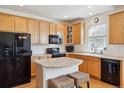 Spacious kitchen features a breakfast bar, stylish backsplash, and modern black appliances at 835 Stony Mesa Pl, Castle Rock, CO 80108