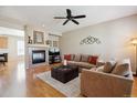 Inviting living room with a cozy fireplace, ceiling fan, and comfortable seating area at 835 Stony Mesa Pl, Castle Rock, CO 80108
