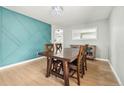 Dining room with a rustic wood table, modern light fixture, and accent wall at 6565 W 99Th Ave, Broomfield, CO 80021