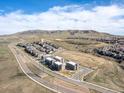 Aerial view showcasing a community of new townhomes with a mountain backdrop and open space at 2225 S Poppy St, Lakewood, CO 80228