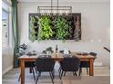 Stylish dining area with a modern light fixture and a unique wall-mounted vertical garden feature at 2225 S Poppy St, Lakewood, CO 80228