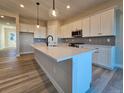 Bright kitchen featuring a large center island with white countertops, stylish cabinets, and modern stainless steel appliances at 5930 S Platte Canyon Dr, Littleton, CO 80123