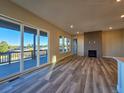 Open-concept living room with hardwood floors, a fireplace, and large sliding glass doors leading to the outdoor patio at 5930 S Platte Canyon Dr, Littleton, CO 80123