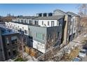 Modern townhome complex featuring a gray and white exterior, rooftop decks, and well-maintained landscaping at 3735 Kalamath St # 3, Denver, CO 80211