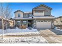 Two-story house with a gray exterior, stone accents, and a three-car garage at 16382 Spanish Peak Way, Broomfield, CO 80023