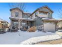 Two-story house with gray exterior, stone accents, and three-car garage, snow on ground at 16382 Spanish Peak Way, Broomfield, CO 80023