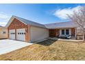 Charming brick and siding home with a well-manicured front lawn and attached garage at 4900 Beverly Dr, Berthoud, CO 80513