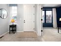 Bright entryway with a white door, gray walls, and a small table at 3319 Emily St, Castle Rock, CO 80109