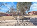 Charming single-story brick home with mature trees and a well-kept lawn on a sunny day at 3272 W Stanford W Ave, Englewood, CO 80110